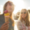 women smiling eating ice cream after having microneedling treatment